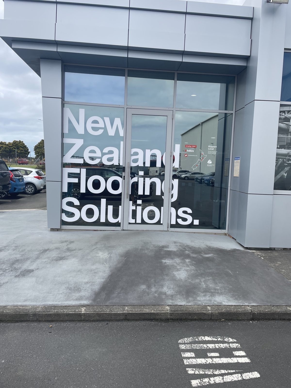 New Zealand Flooring Solutions window lettering with Feltex and Godfrey Hirst logos